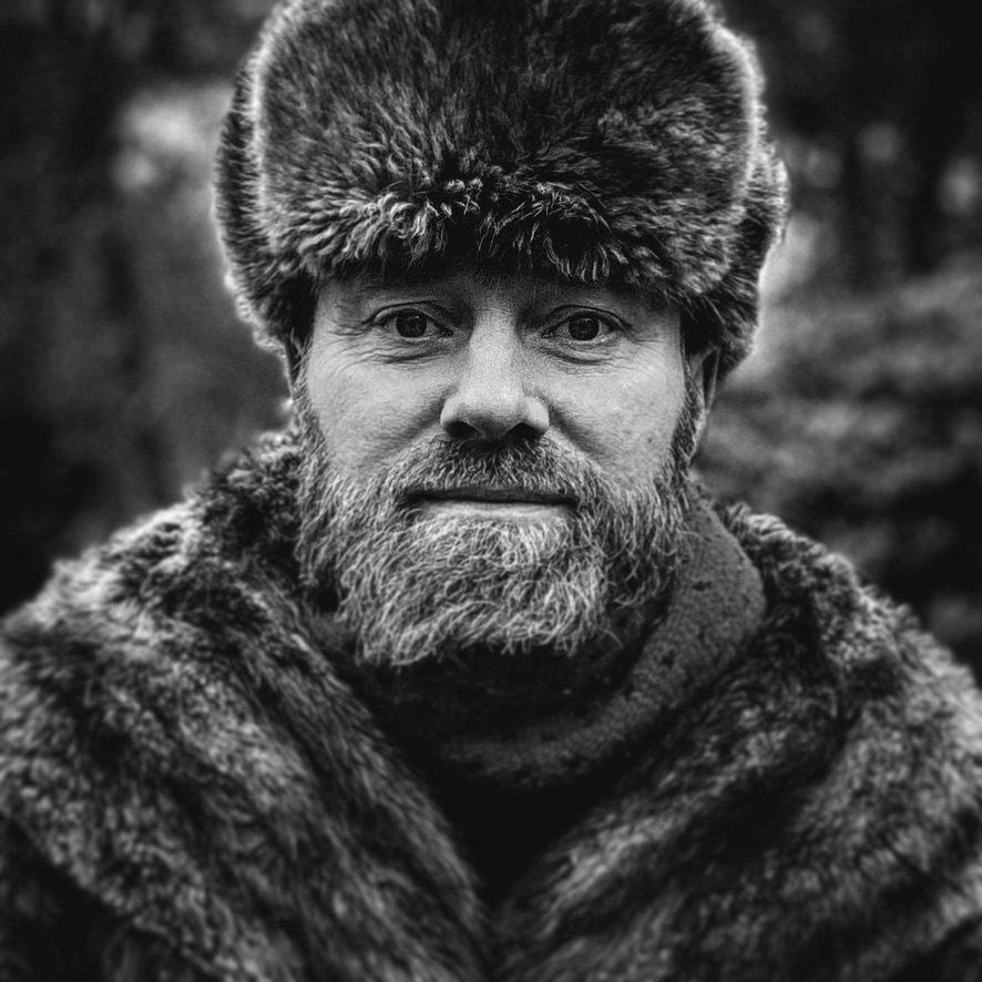 Black and white portrait of Perry in a fur hat and coat