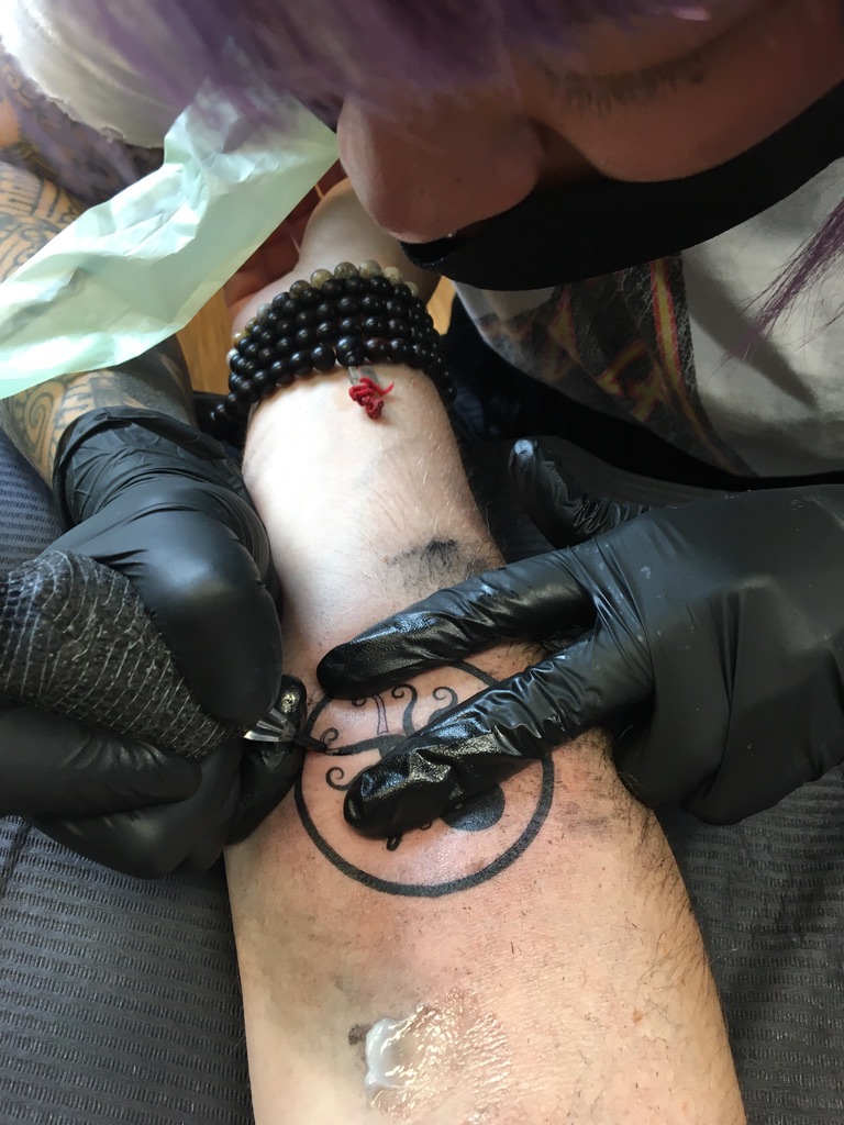 Close-up of an octopus tattoo being inked on Perry's leg