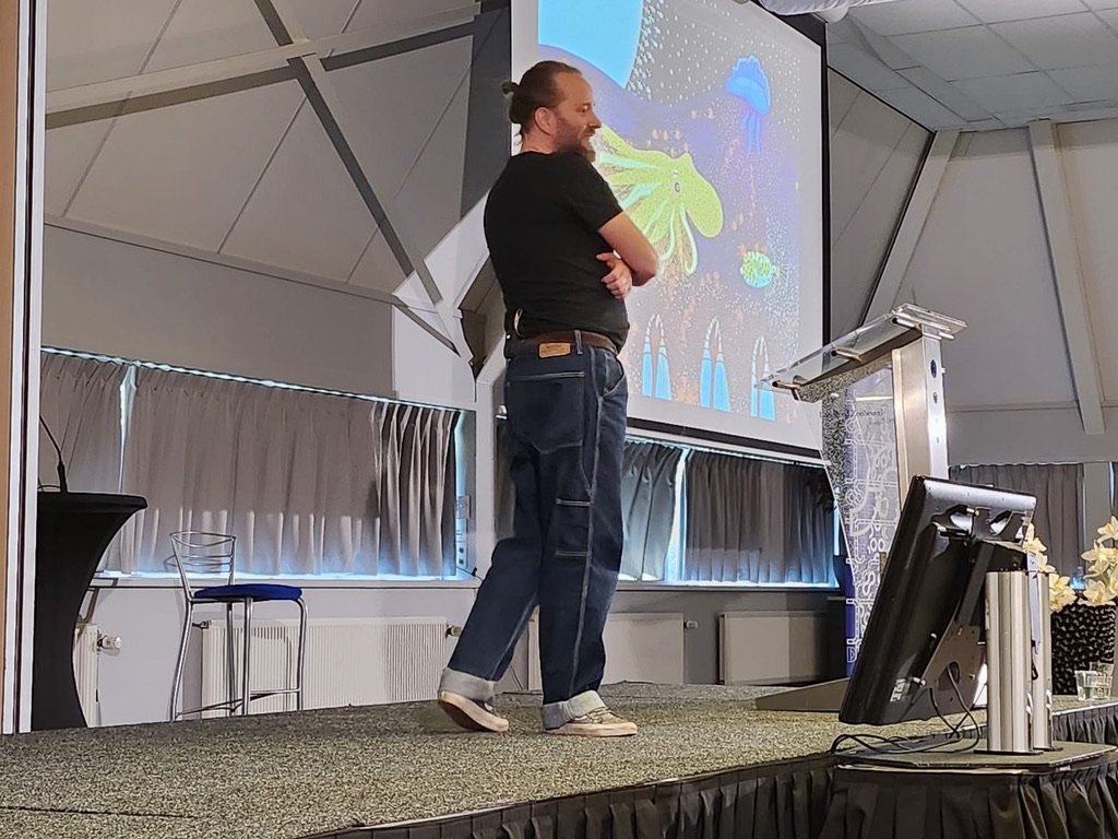 Perry on stage in front of an octopus illustration