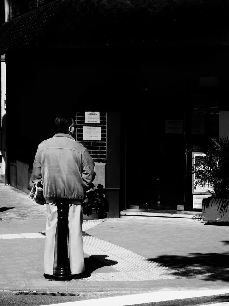 A man standing alone on a quiet street corner, Brussels, 2020
